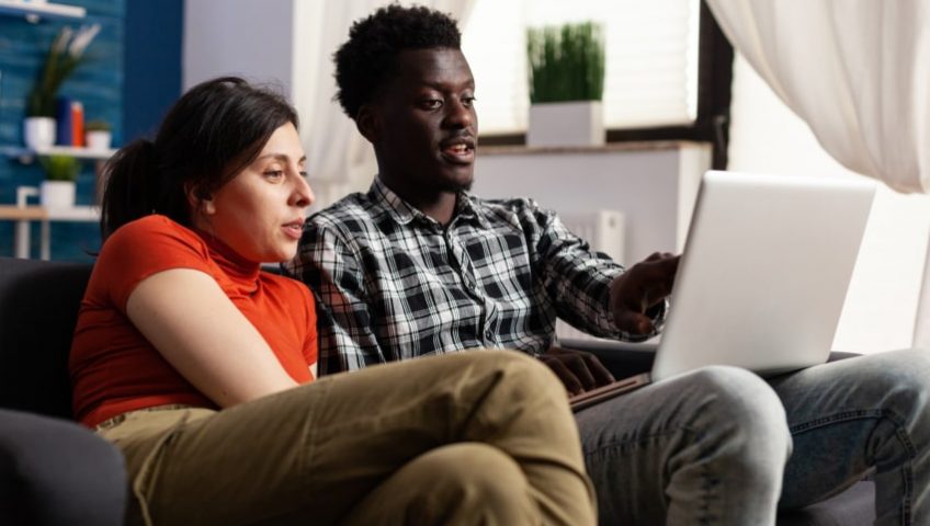 Couple on laptop researching how long furnaces last in Ontario
